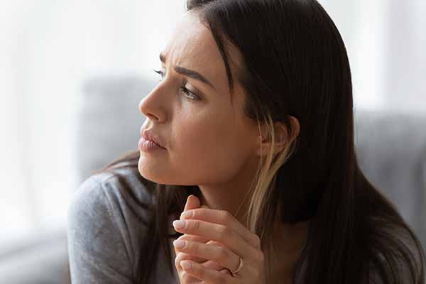 Close up of young woman look in window distance thinking pondering of life problems, thoughtful millennial girl lost in thoughts feel troubled concerned or frustrated make decision